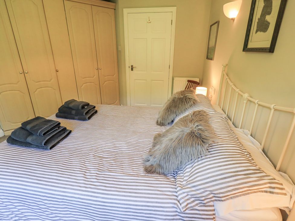 A bedroom with a bed and towels on it at Doe Foot Cottage Ingleton