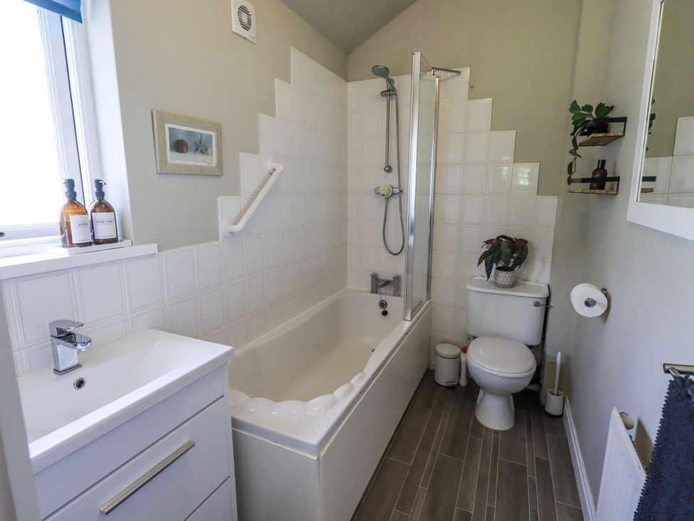 A bathroom with a bathtub, toilet, sink, and shower at Doe Foot Cottage in Ingleton
