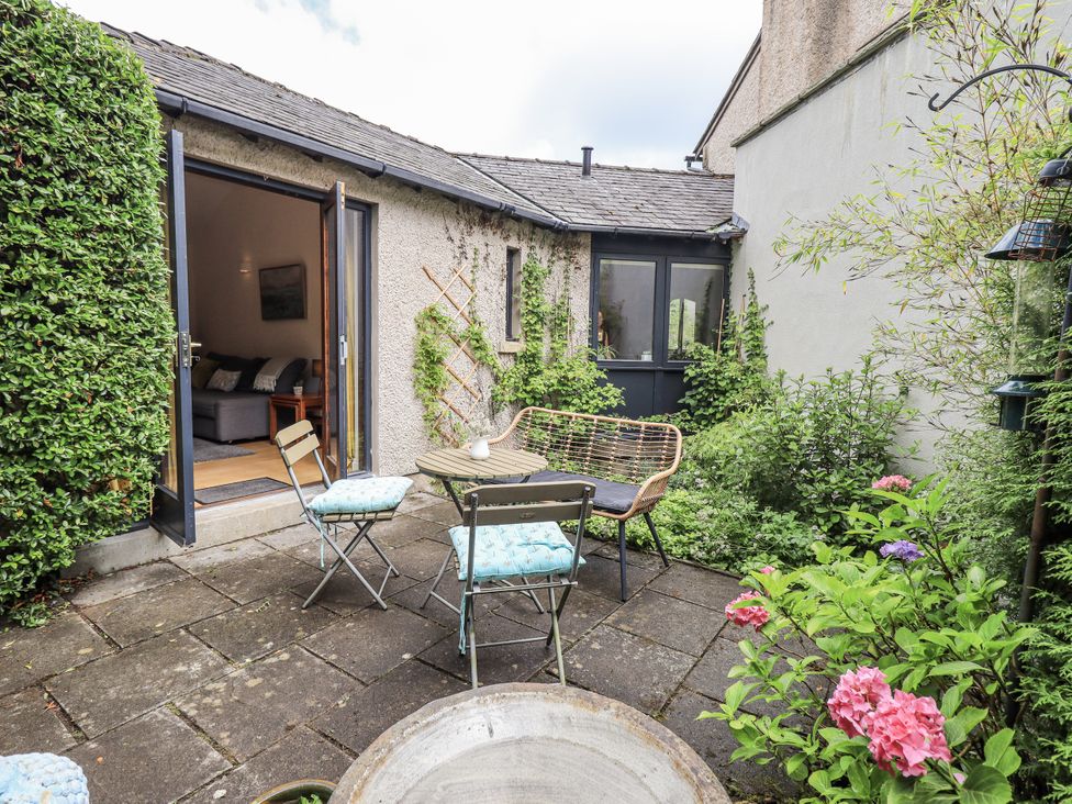A garden with chairs and a table at Doe Foot Cottage in Ingleton