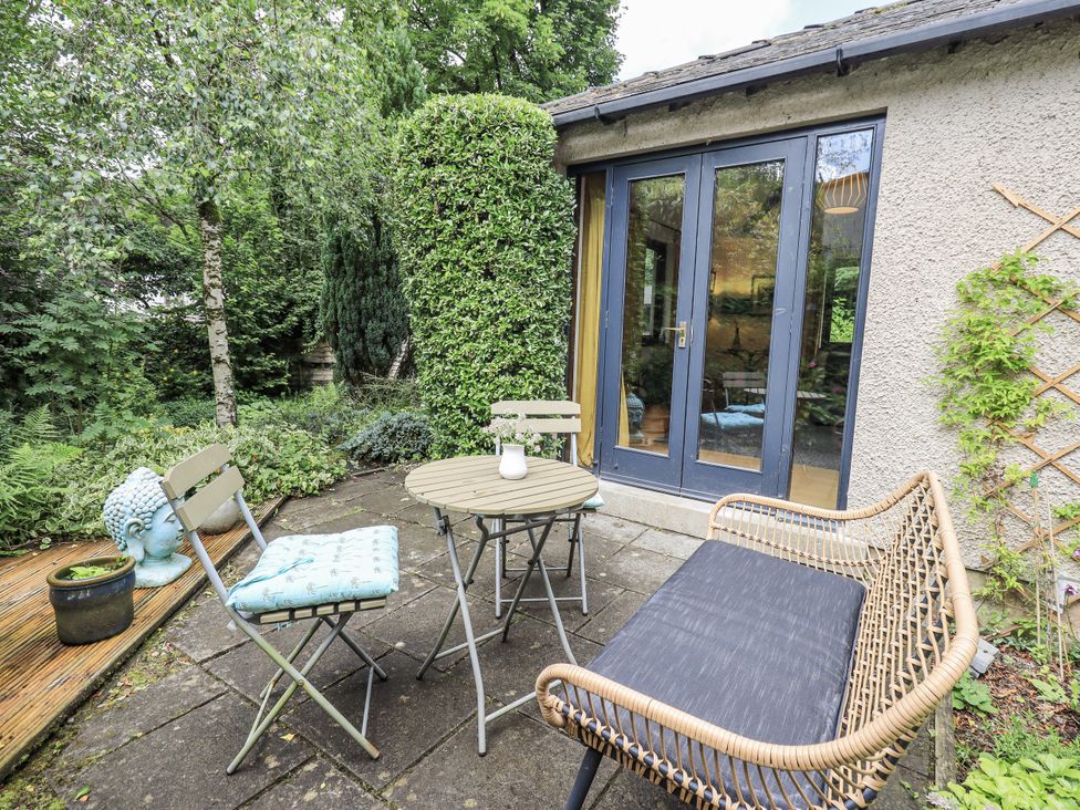 An outdoor seating area with a table and chairs at Doe Foot Cottage Ingleton