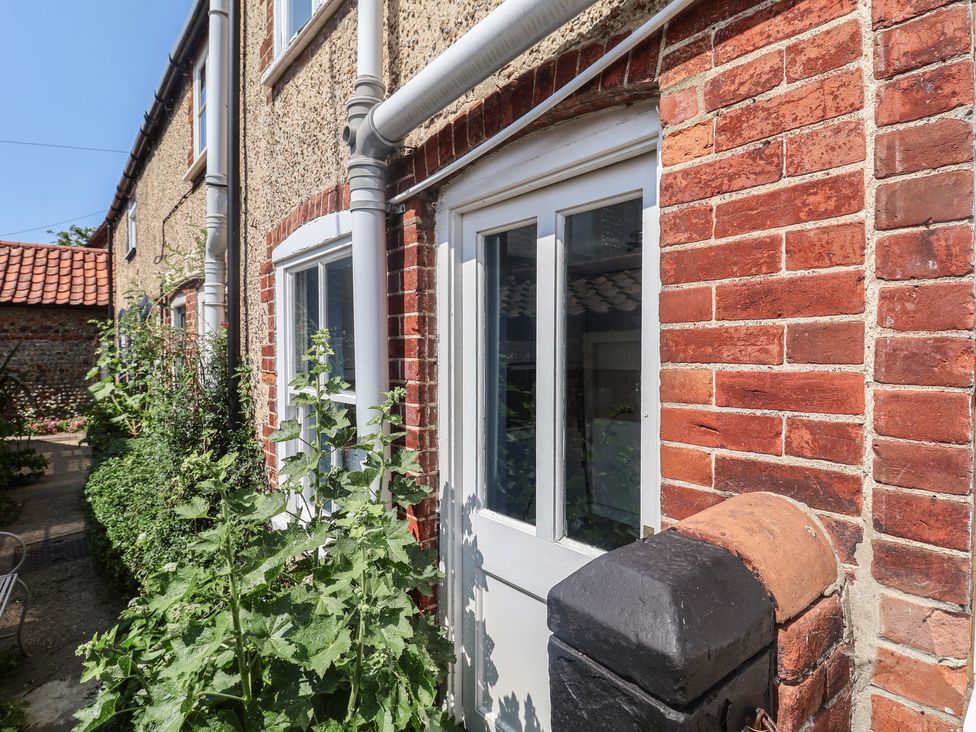 A door and window with surrounding plants at Delphinium in Blakeney, Norfolk