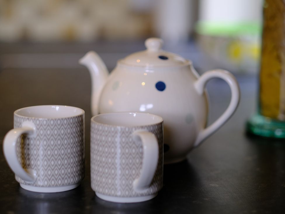 A teapot and two mugs on a surface at Long Meadow in Midhurst