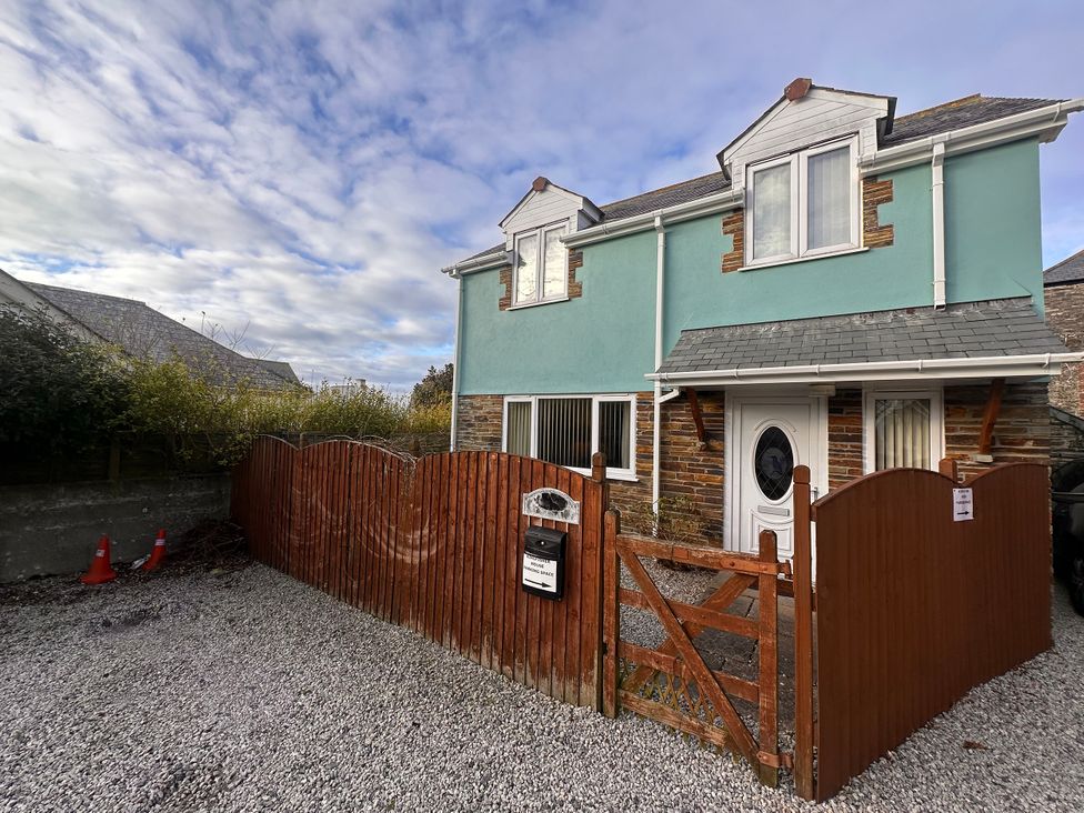 A house with a gravel driveway and a wooden gate at Kingfisher House in Tintagel