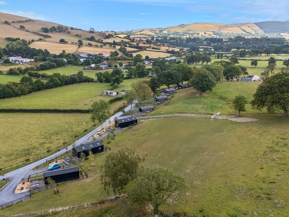 An aerial view of fields and cabins at Hillside Lodge Nantmel near Rhayader