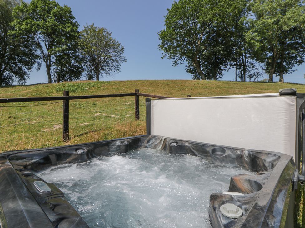A hot tub with water in an outdoor area at Hillside Lodge Nantmel near Rhayader
