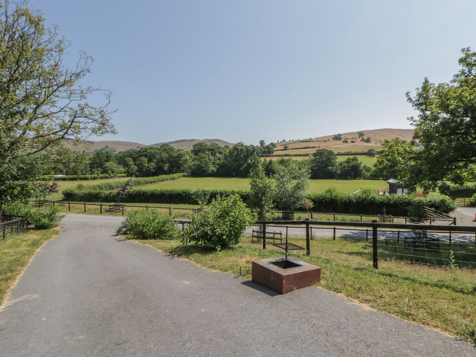 An outdoor landscape with a road and trees at Hillside Lodge Nantmel near Rhayader
