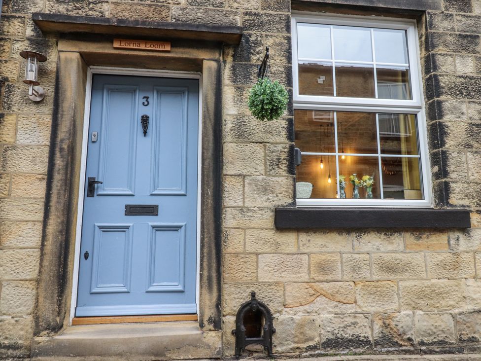 A blue door with a window and sign at Lorna Loom in Skipton