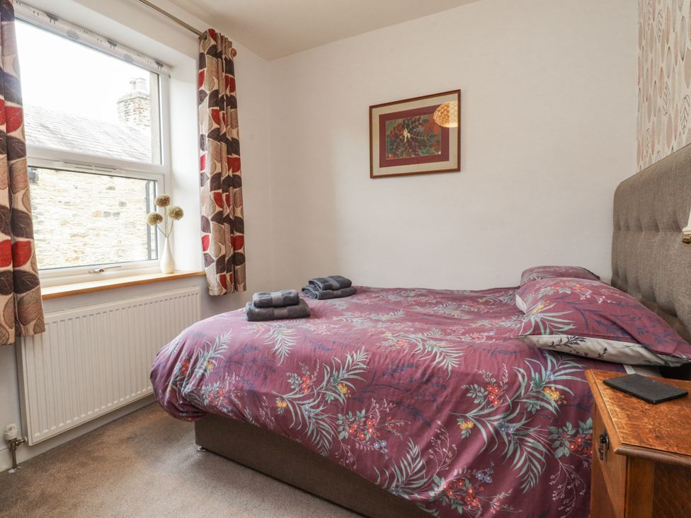 A bedroom with a bed and towels on the side at Lorna Loom in Skipton