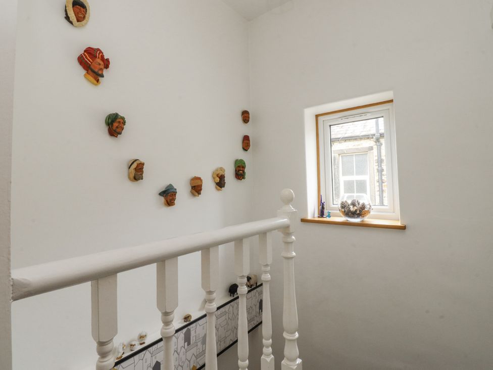 A staircase with decorative heads on the wall at Lorna Loom in Skipton