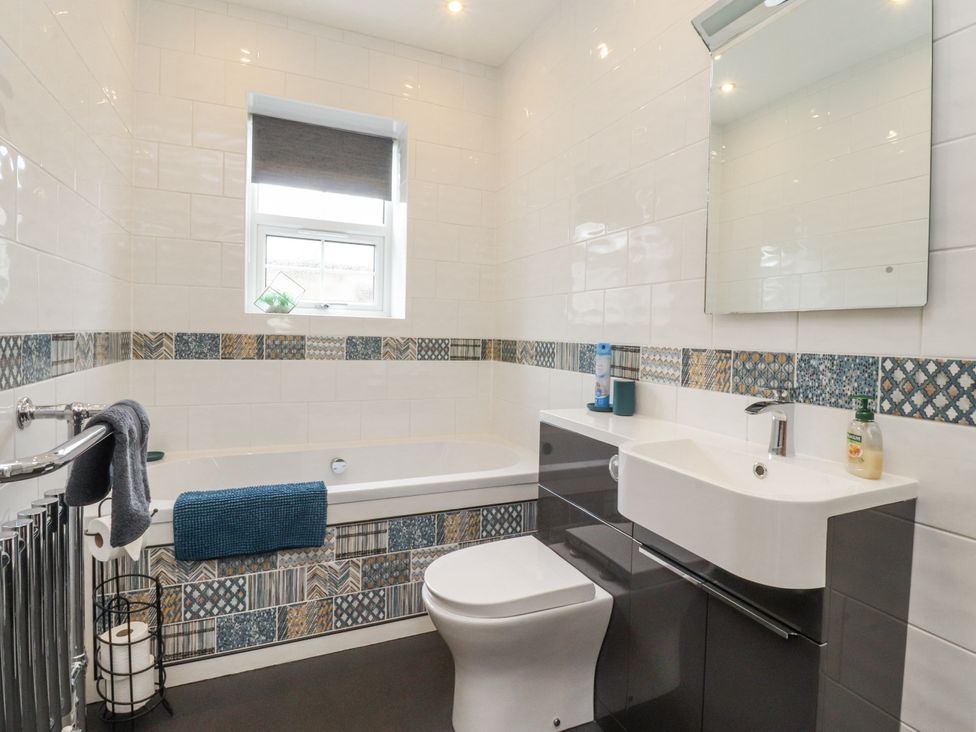 A bathroom with a bathtub, toilet, and sink at Lorna Loom in Skipton