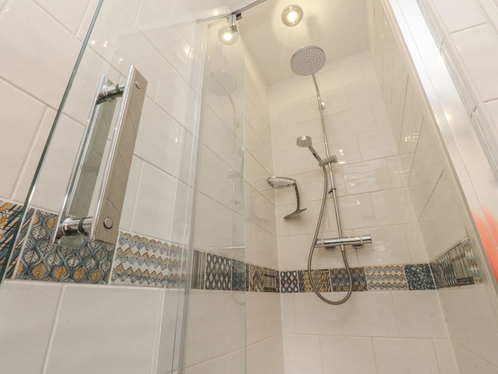 A shower enclosure with a glass door and tiled walls at Lorna Loom in Skipton