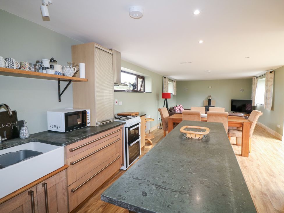 A kitchen with sink, stove, and dining area at The Owl's Hoot in Tacumshane, County Wexford