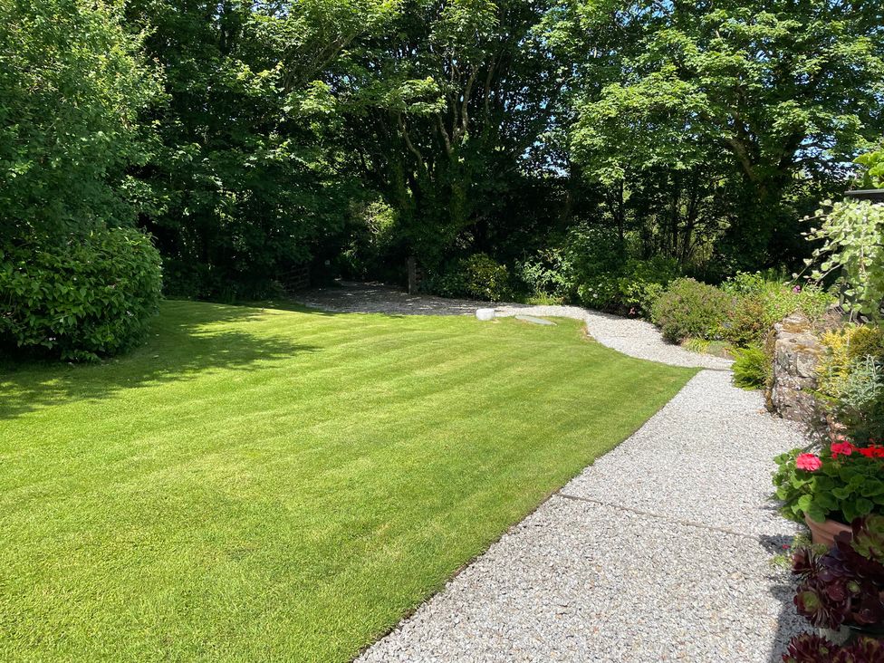 A garden with a gravel path and grass at Garden Cottage in St Just