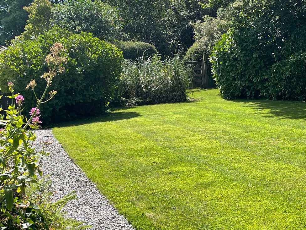 A garden with grass and plants at Garden Cottage in St Just