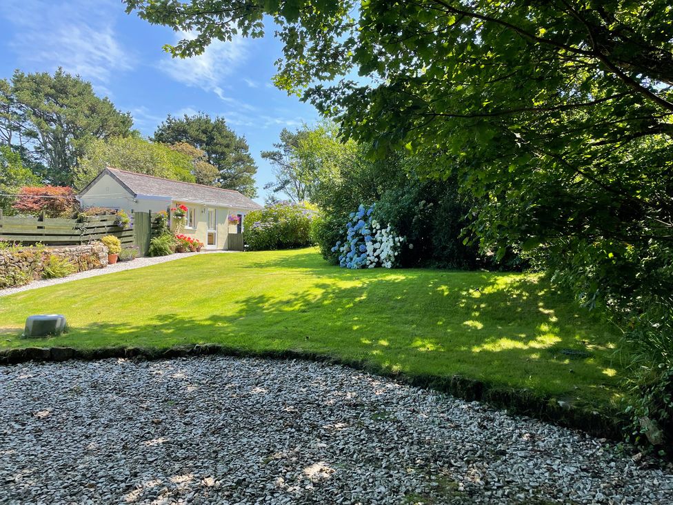 A garden with a cottage and flowers at Garden Cottage in St Just