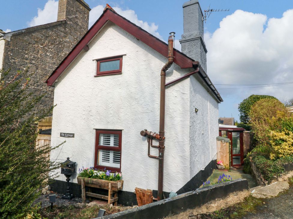 An outdoor view of a cottage with a garden and pathway at The Cottage Marian-Glas