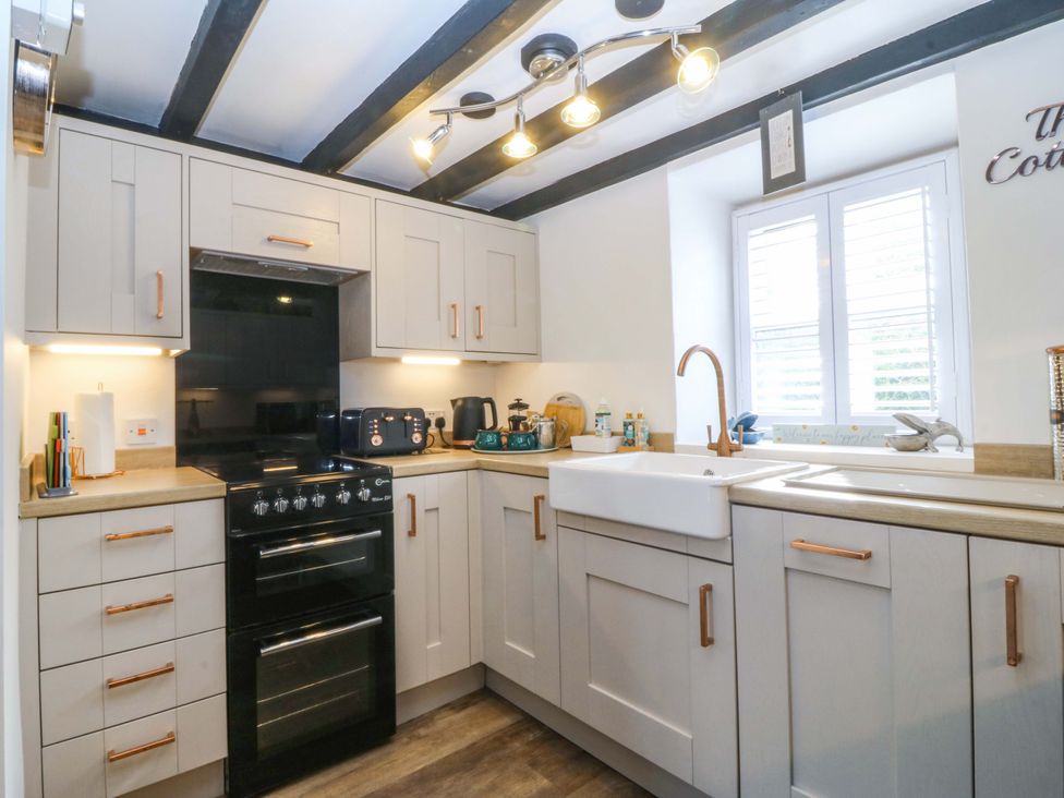 A kitchen with cabinets and an oven at The Cottage in Marian-Glas