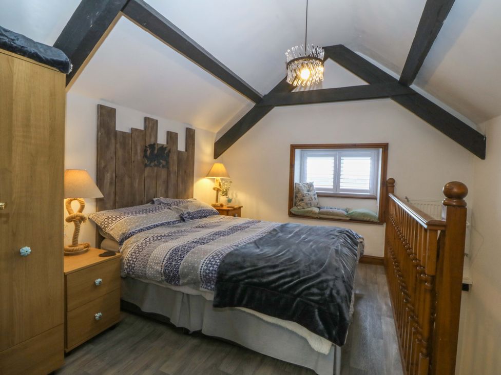 A bedroom with a bed and window seat at The Cottage in Marian-Glas