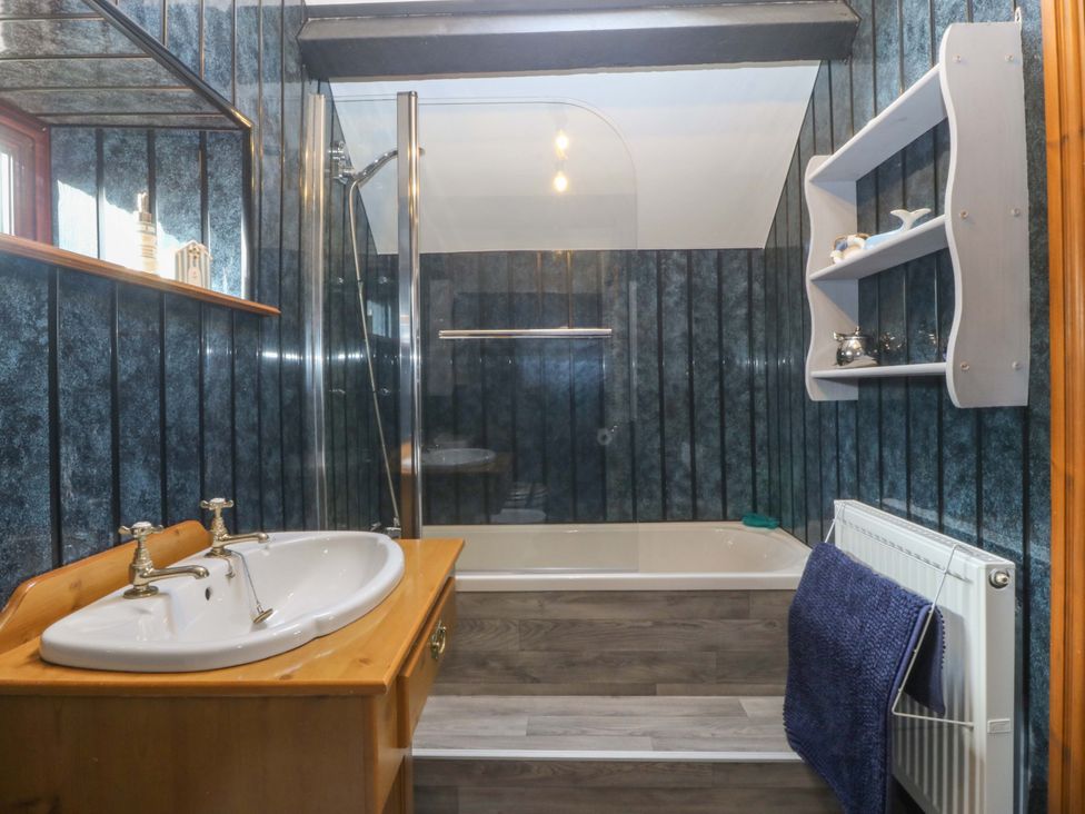 A bathroom with a sink and bathtub at The Cottage Marian-Glas