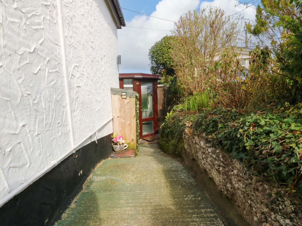 A garden path leading to a door with plants at The Cottage in Marian-Glas