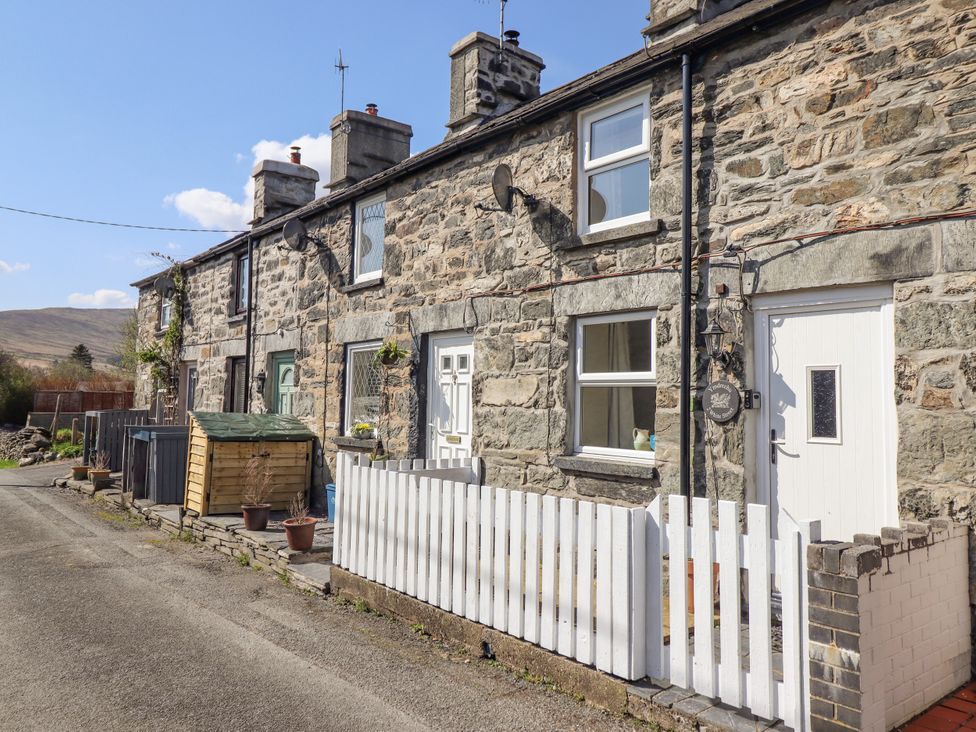 A stone terrace house with a fence and garden shed at 2 White Street Penmachno