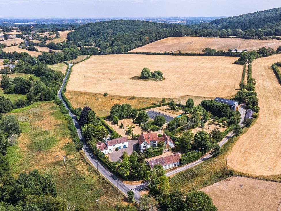 An aerial view of a property with fields and trees at Lower Tundridge Cottage Suckley near Malvern