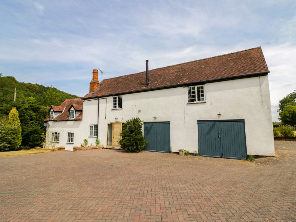 A house with garage doors and driveway at Lower Tundridge Cottage Suckley near Malvern