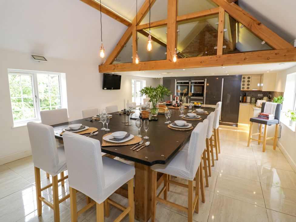 A kitchen with a dining area and modern appliances at Lower Tundridge Cottage Suckley near Malvern