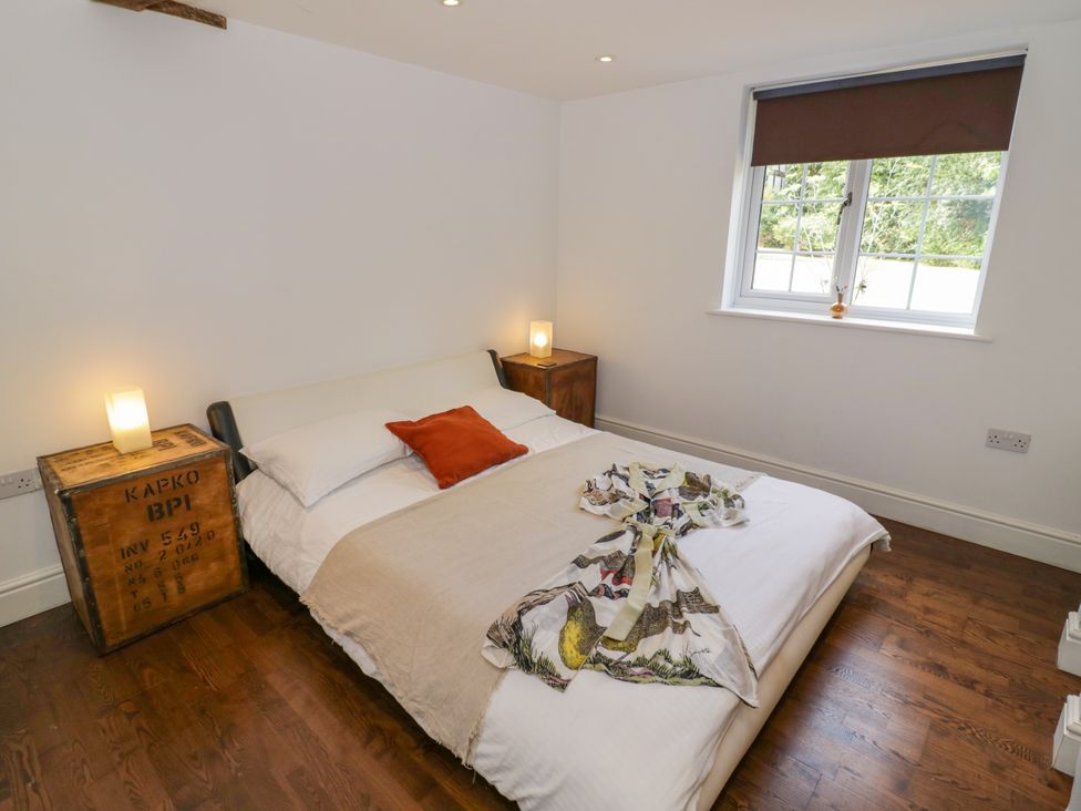 A bedroom with a bed and wooden furniture at Lower Tundridge Cottage Suckley near Malvern