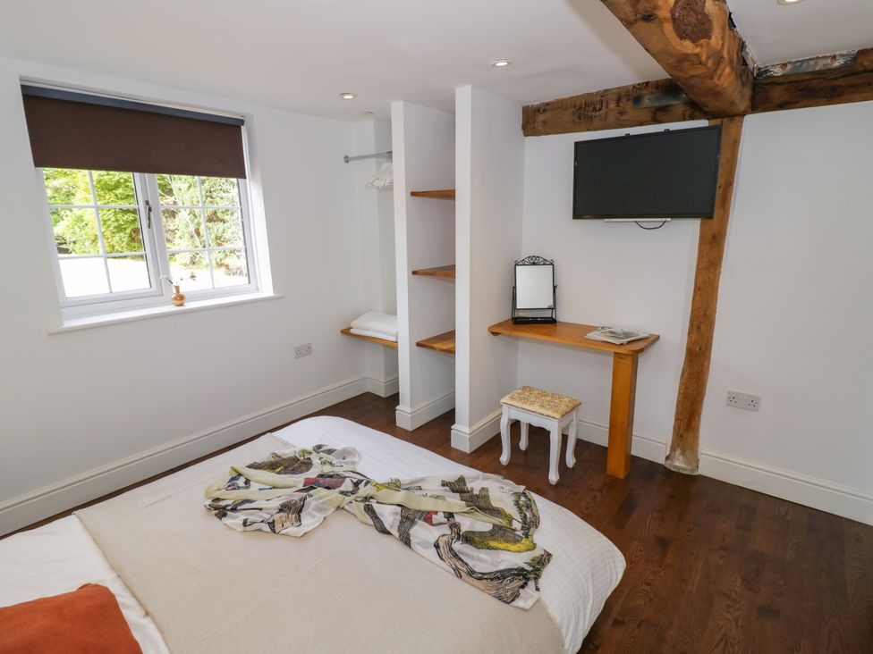 A bedroom with a bed and a television at Lower Tundridge Cottage Suckley near Malvern