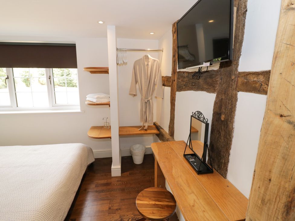 A bedroom with a bed and a television at Lower Tundridge Cottage in Suckley near Malvern