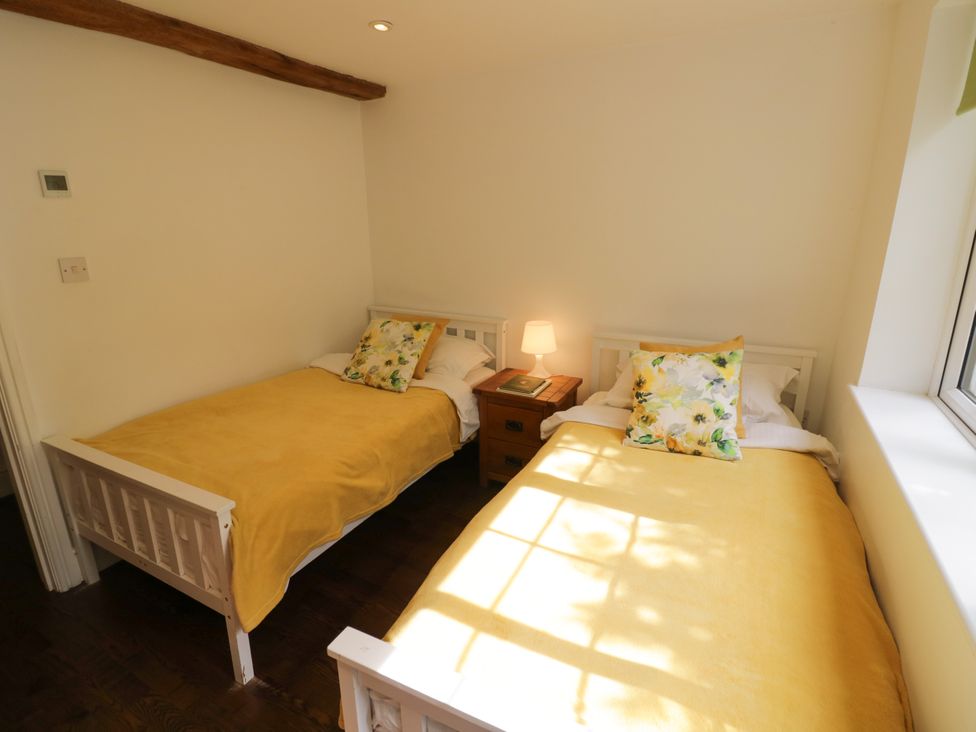 A bedroom with two beds and a lamp at Lower Tundridge Cottage Suckley near Malvern