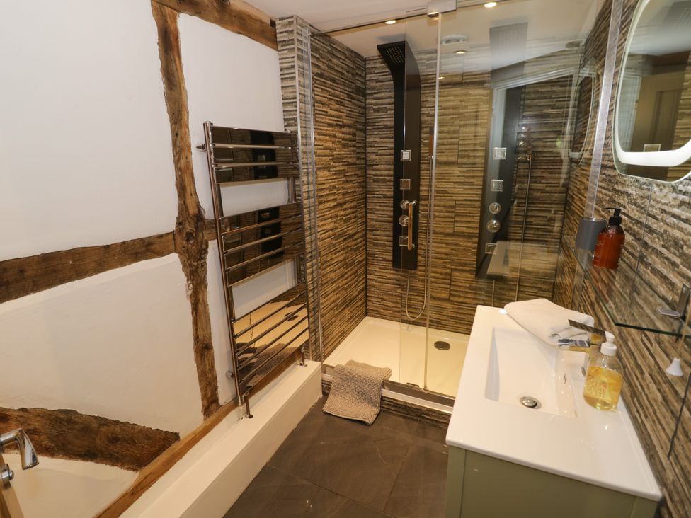 A bathroom with a shower and bathtub at Lower Tundridge Cottage Suckley near Malvern