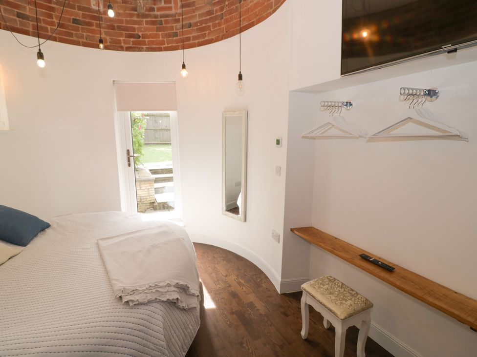 A bedroom with a bed and a mirror at Lower Tundridge Cottage Suckley near Malvern