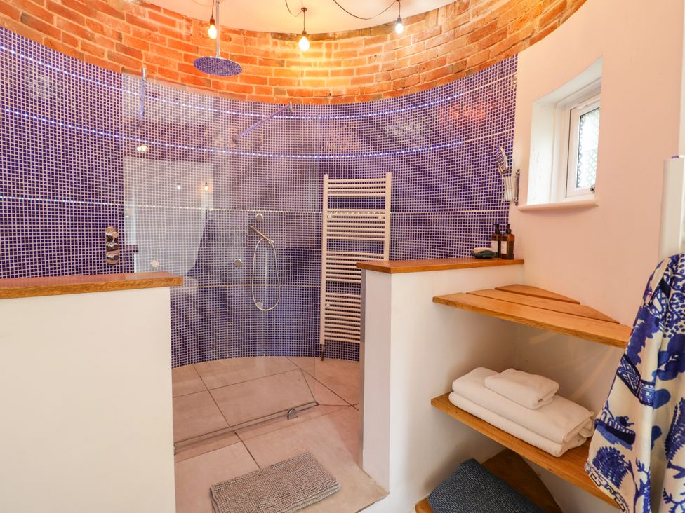 A bathroom with a shower and towel rack at Lower Tundridge Cottage Suckley near Malvern