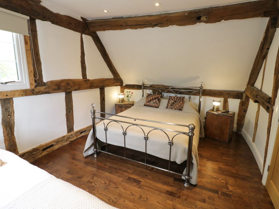 A bedroom with a bed and wooden beams at Lower Tundridge Cottage, Suckley near Malvern