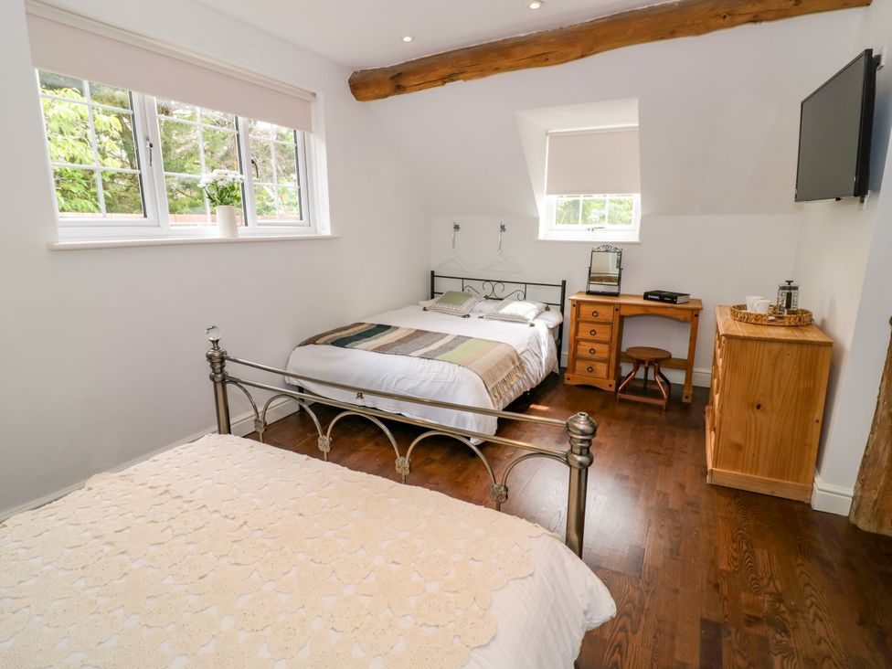 A bedroom with two beds and a desk at Lower Tundridge Cottage Suckley near Malvern