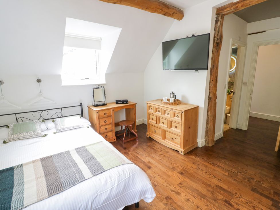 A bedroom with a bed, television, and a desk at Lower Tundridge Cottage Suckley near Malvern
