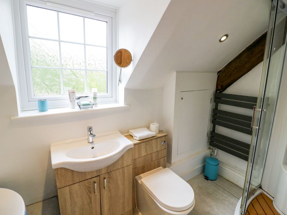 A bathroom with sink, toilet, shower and window at Lower Tundridge Cottage Suckley near Malvern