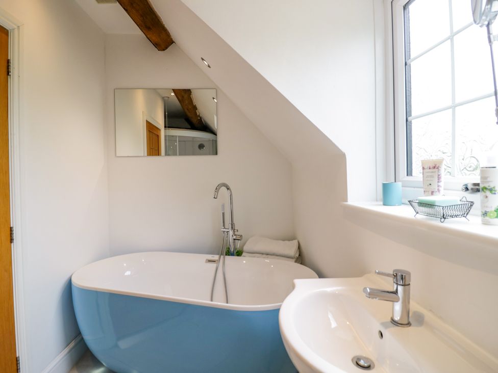A bathroom featuring a bathtub and a sink at Lower Tundridge Cottage Suckley near Malvern