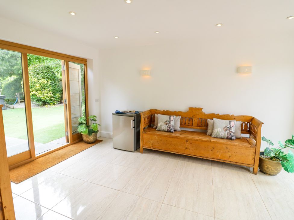 A snug with a wooden bench and small refrigerator at Lower Tundridge Cottage Suckley near Malvern
