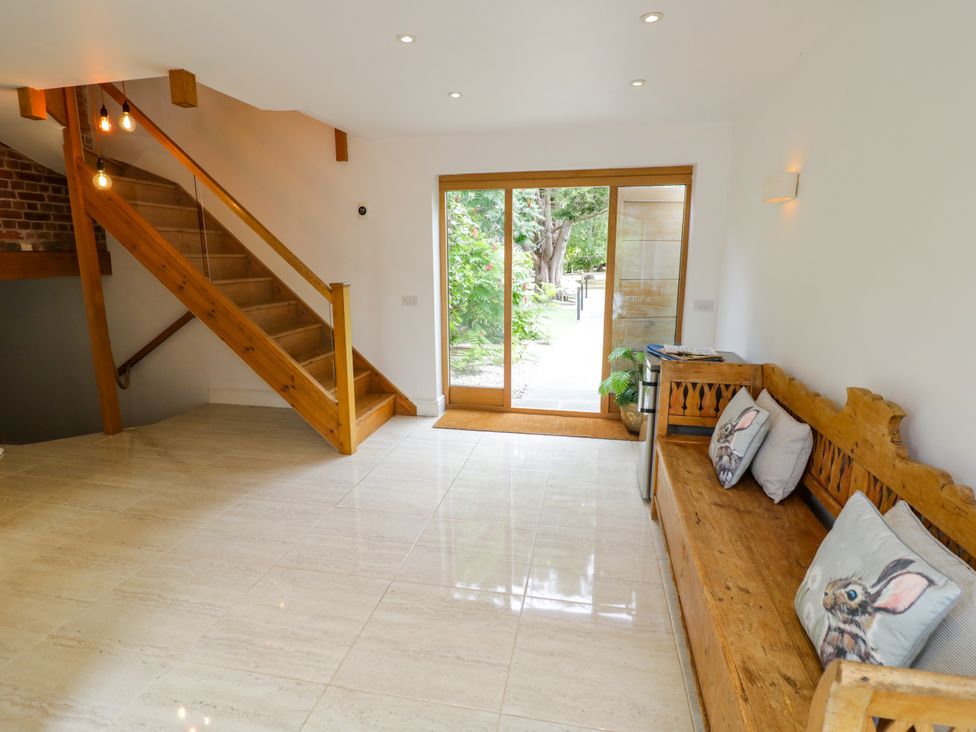 An entrance hall with a staircase and a bench at Lower Tundridge Cottage Suckley near Malvern