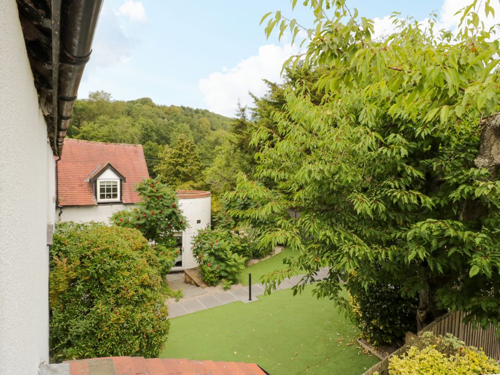 A view of houses and trees in the garden at Lower Tundridge Cottage Suckley near Malvern