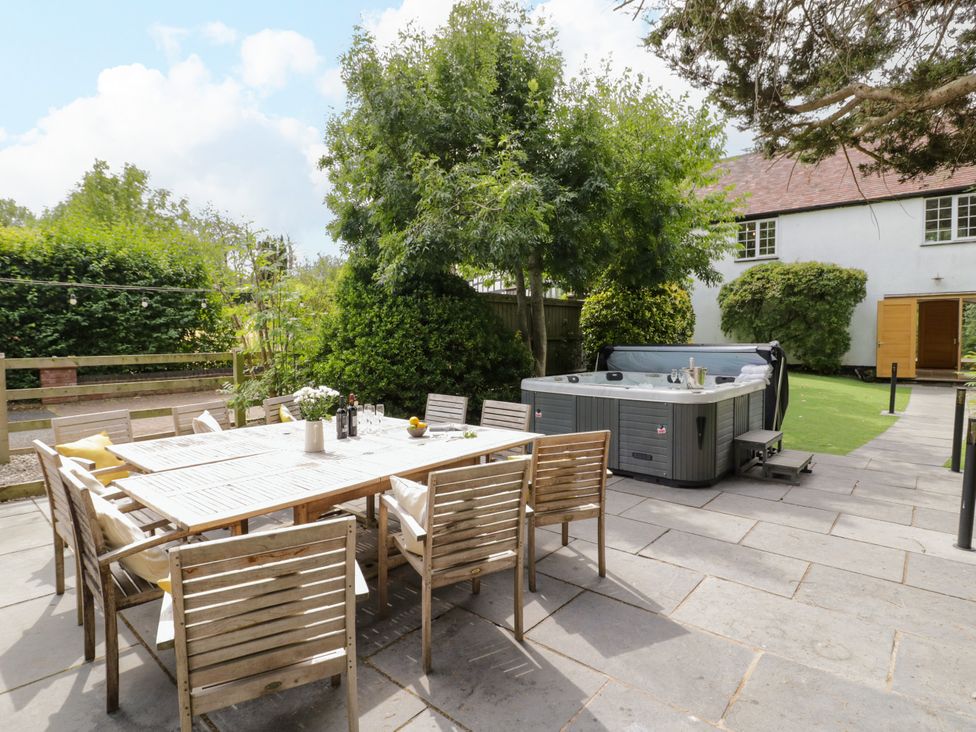 A garden with a dining table and a hot tub at Lower Tundridge Cottage Suckley near Malvern