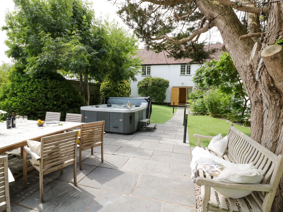 A garden with a hot tub and seating area at Lower Tundridge Cottage Suckley near Malvern