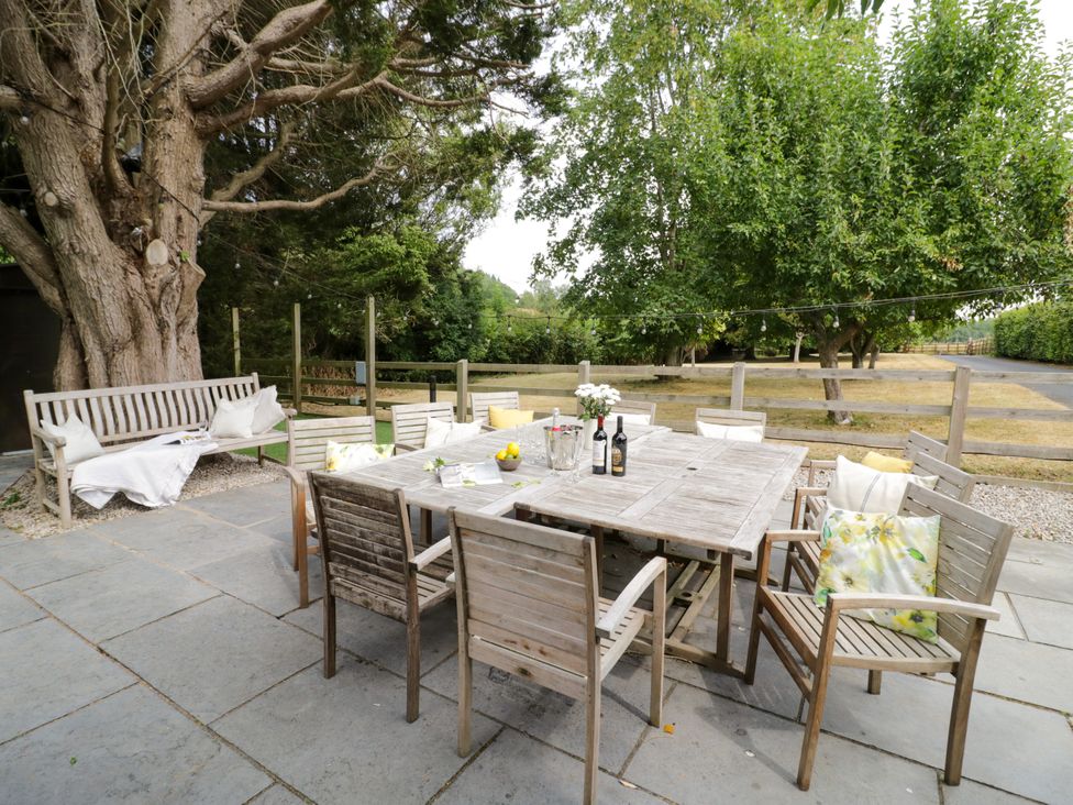 An outdoor dining area with a wooden table and chairs at Lower Tundridge Cottage, Suckley near Malvern