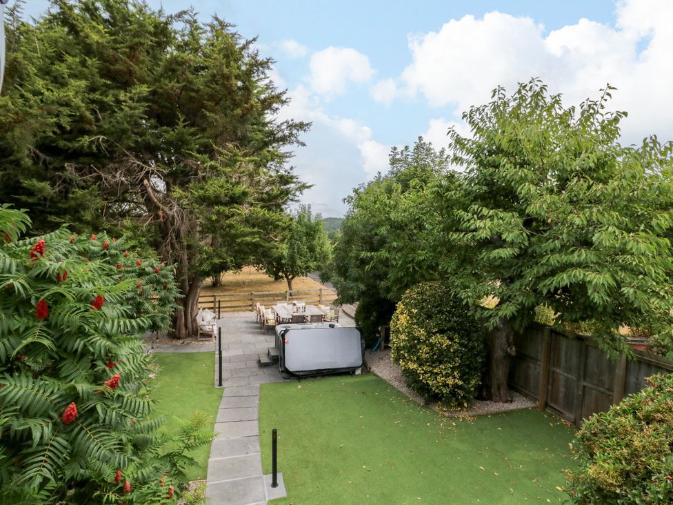 A garden with trees and seating area at Lower Tundridge Cottage in Suckley near Malvern