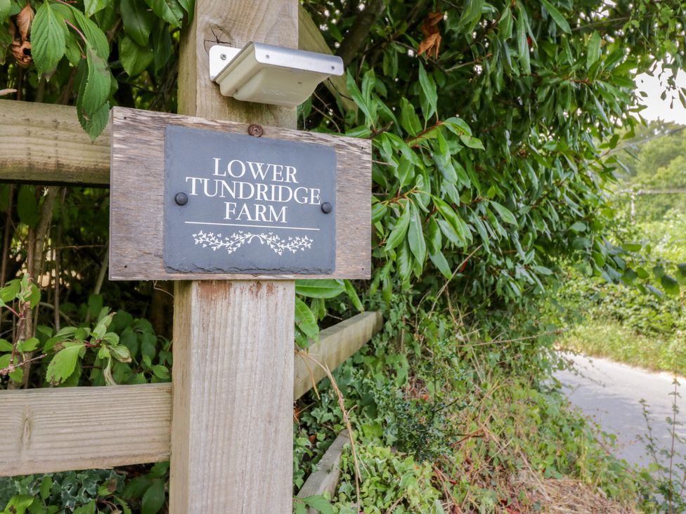 A sign for Lower Tundridge Farm on a wooden post outdoors at Lower Tundridge Cottage Suckley near Malvern