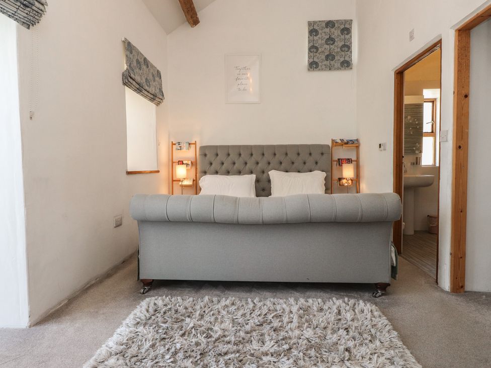 A living room with a couch and window at Wern Olau Cottage in Groeslon near Caernarfon