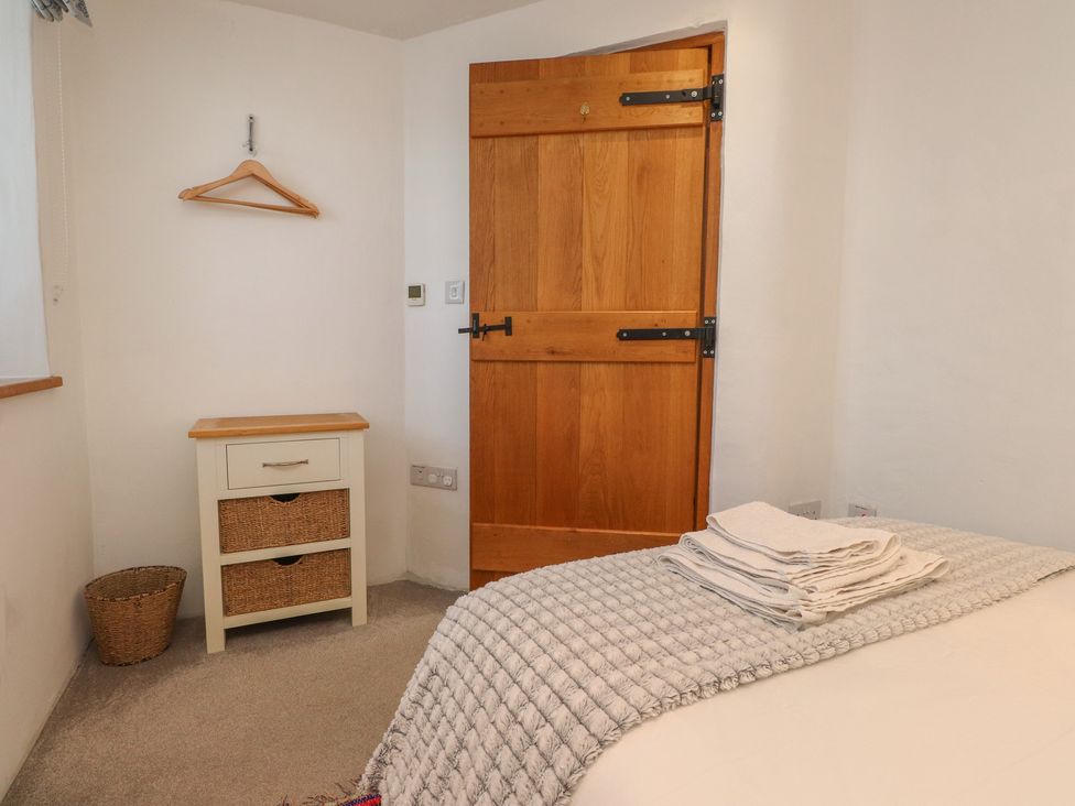 A bedroom with a bed and drawer unit at Wern Olau Cottage in Groeslon near Caernarfon